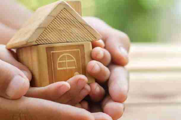 Handen vouwen zich om woonhuis heen